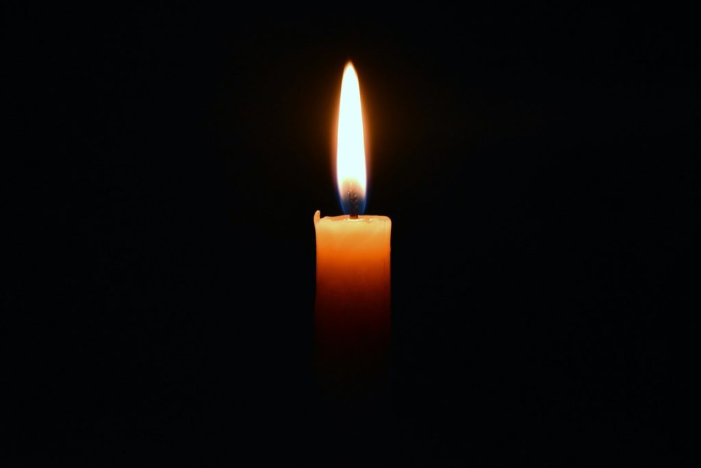a lit candle in the dark